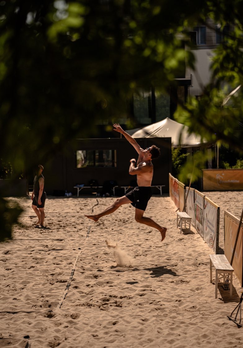 Christian Rawe im Sprung zum Angriff auf einem Berliner Beachvolleyballfeld